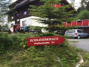 A sign for 'SCHLESIERHAUS Weiherhalle 32' with a building in the background. - Apartment '3' with Shared Terrace, Balcony and Wi-Fi (Dachsberg (Südschwarzwald))
