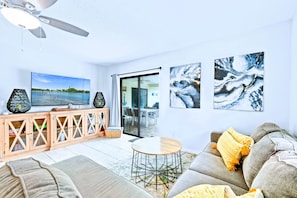 A living room with a sofa, coffee table, and artwork on the walls. - Luxury Sleeps 12 Kings Pool 2 Hot Tubs (Palm Beach Gardens)