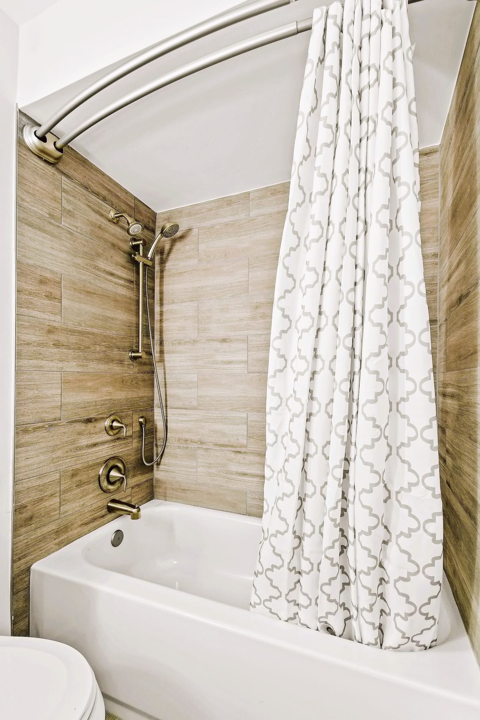A bathroom with a bathtub, shower, and toilet.