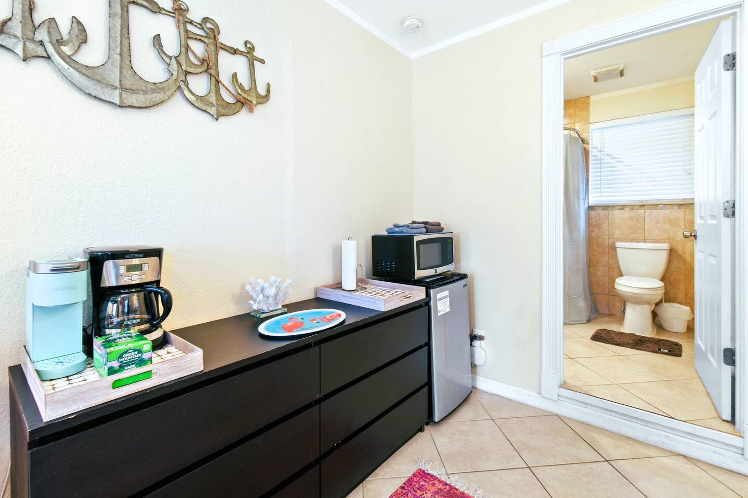 A kitchenette with a coffee maker, microwave, and small refrigerator.
