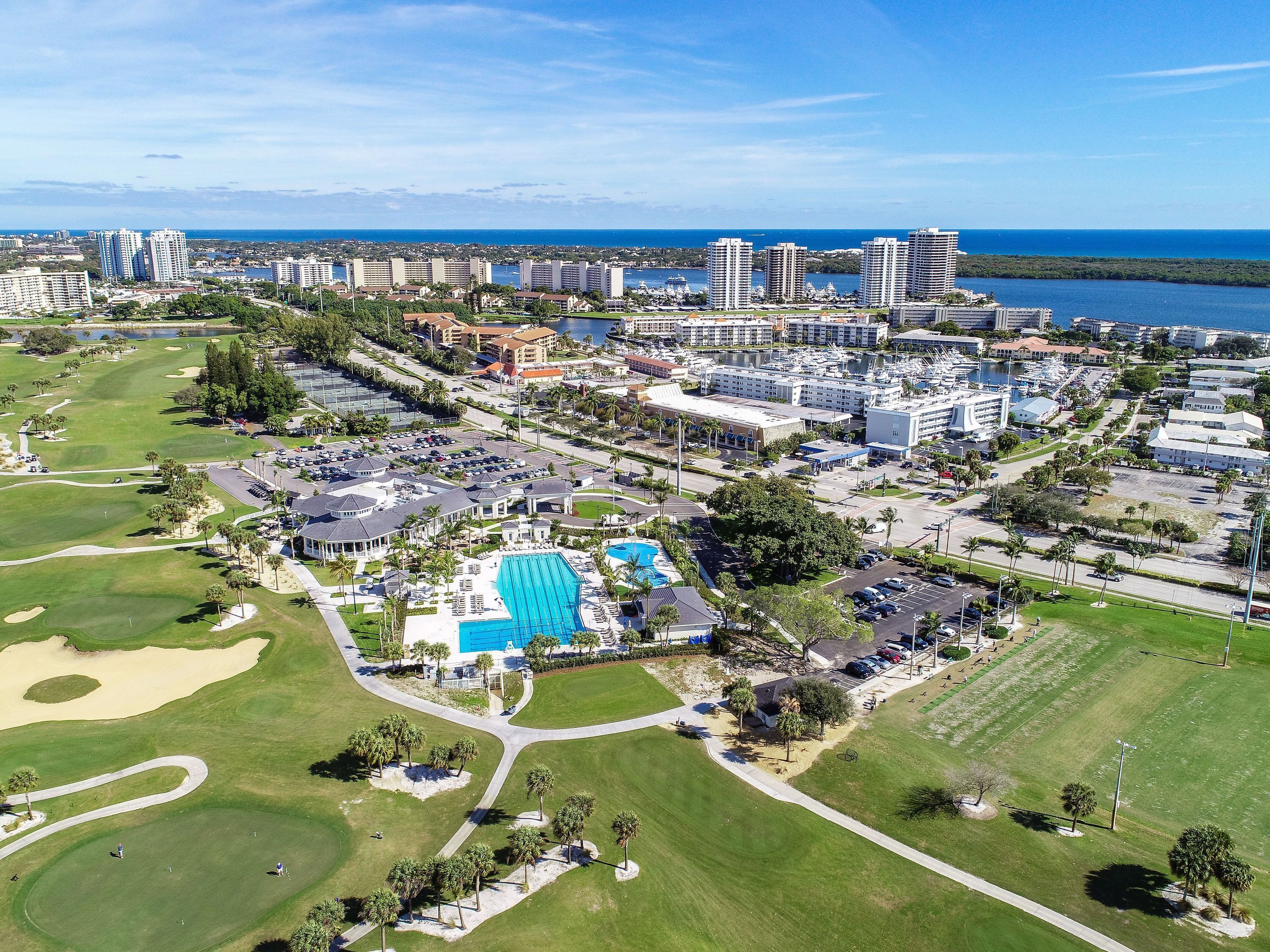 Vista aérea de um campo de golfe com piscina, rodeado por hotéis e edifícios.