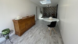 A modern kitchen with a wooden cabinet, a dining table with chairs, and a skylight above. - Peaceful cottage with garden in Savonnières (Savonnières)