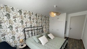 A bedroom with a bed, a nightstand, a chair, a wardrobe, and a hanging light fixture. - Peaceful cottage with garden in Savonnières (Savonnières)