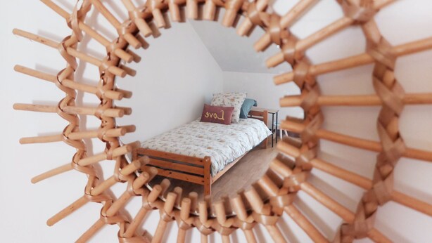 Een rond geweven bouwwerk met een bed.