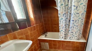 Une salle de bain équipée d’un lavabo, d’une baignoire et d’un rideau de douche.