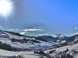 A snow-covered mountain landscape with a village nestled in the valley. - 2-room apartment + mountain corner 39m², sleeps 6, mountain view (Le Grand-Bornand)