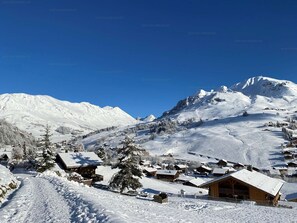 A snow-covered mountain village with wooden buildings and a clear blue sky. - 2-room apartment + mountain corner 39m², sleeps 6, mountain view (Le Grand-Bornand)
