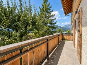Ein Holzbalkon mit Blick auf einen See und Berge.