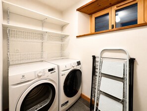 A laundry area with two washing machines, a drying rack, and shelves above. - Spacious chalet 10 pers., near slopes and shops with WIFI (Notre-Dame-de-Bellecombe)