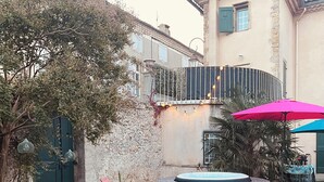 An outdoor seating area with a table, chairs, and a hot tub. - Gîte Montana 3 pers. plein center Mirepoix - Terrace, garden, barbecue (Mirepoix)