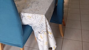 A dining area with a table set for four, a bowl of fruit, and a vase of flowers. - At Lia and Danny's (Rieux-Minervois)