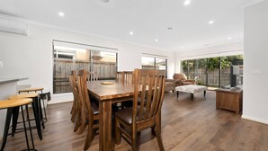 A spacious dining area with a wooden table and chairs, a sofa, and a TV stand. - Happy Cozy Convenient 4BR, Breezy, Near Mall, Park (Berwick)