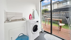 A modern laundry room with a washing machine, a sink, and a drying rack. - Happy Cozy Convenient 4BR, Breezy, Near Mall, Park (Berwick)