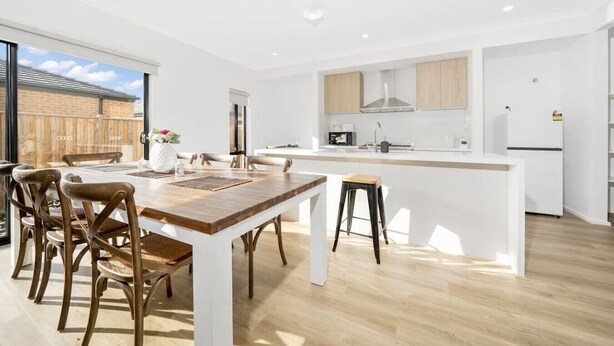 A modern kitchen with a central island, wooden chairs, and a large dining table. - `Brand New`, Spacious, Breezy Comfy, Luxury Home ! (Berwick)