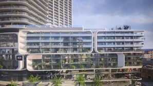 Un immeuble moderne à plusieurs étages, doté de balcons, de grandes fenêtres et d’un toit plat.