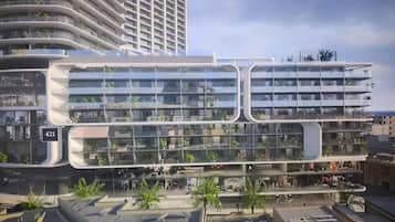 A modern multi-story building with balconies, large windows, and a flat roof.