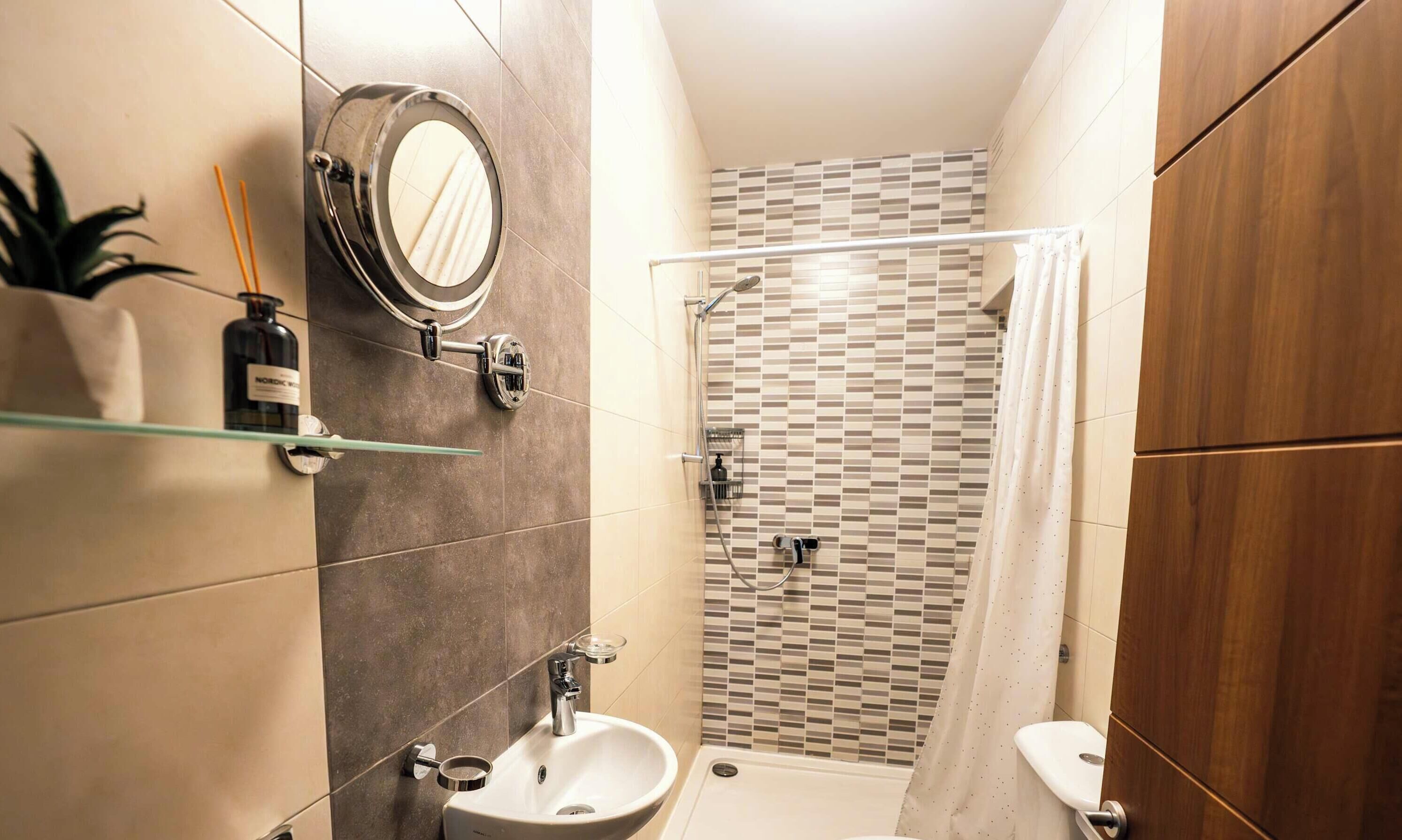 A modern bathroom with a shower, toilet, and sink.
