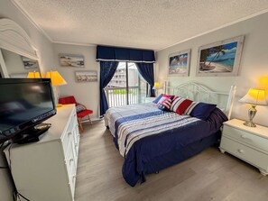 A hotel room with a bed, a TV, a desk, and a chair. - Tilghman Beach and Racquet Club 240 (North Myrtle Beach)