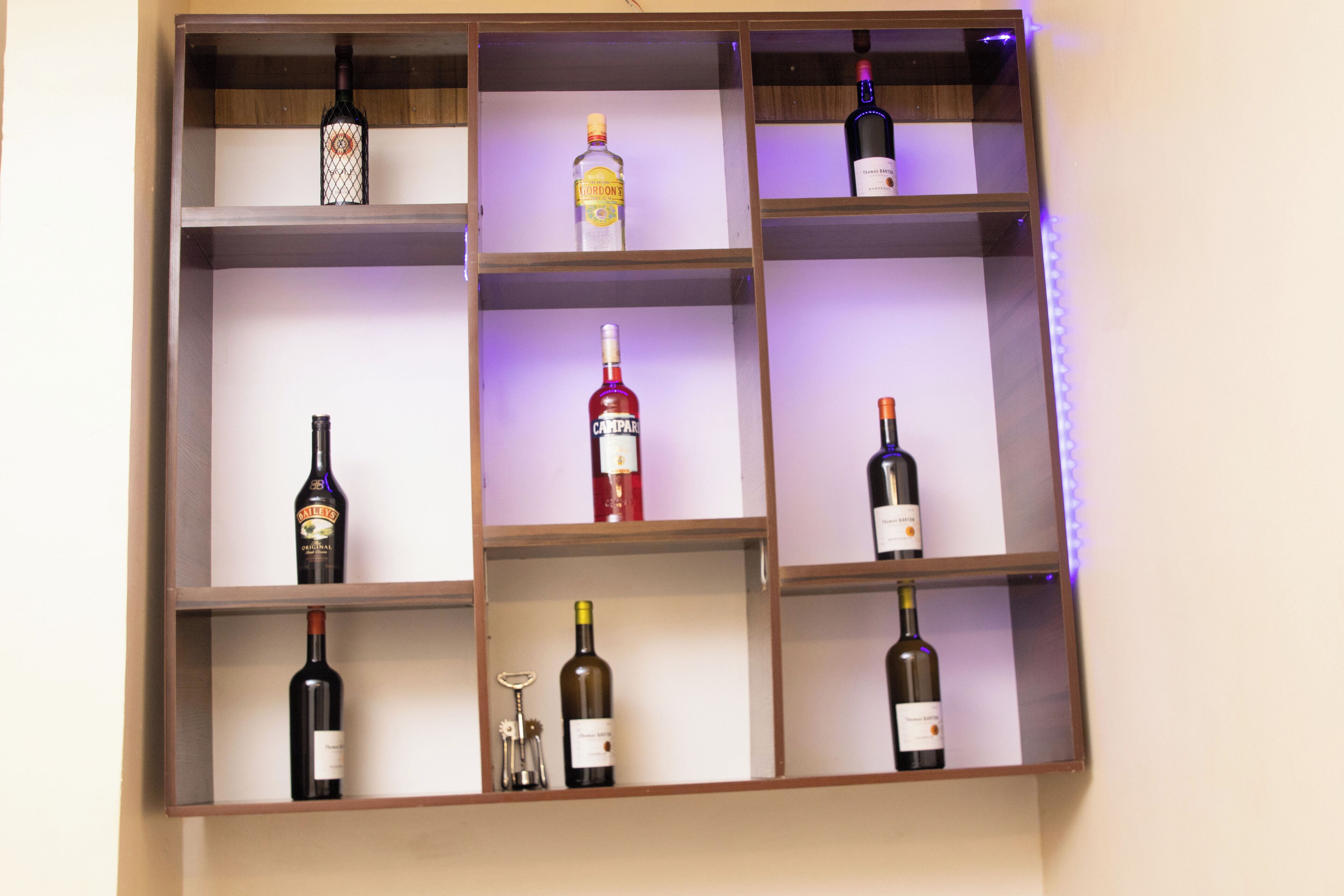 A wine rack with multiple shelves holding various bottles of wine.