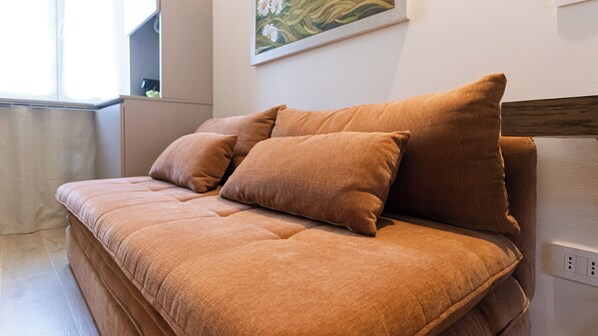 A modern bedroom with a large bed, a wooden headboard, and a painting on the wall. - Italianway Comfort - Monza 9 (Milan)