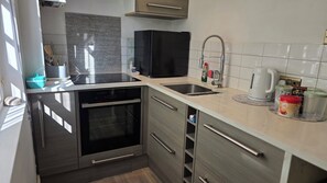 Oven, stovetop, electric kettle, cookware/dishes/utensils
