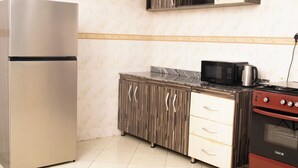 A kitchen with a stainless steel refrigerator, a microwave, and a red stove.