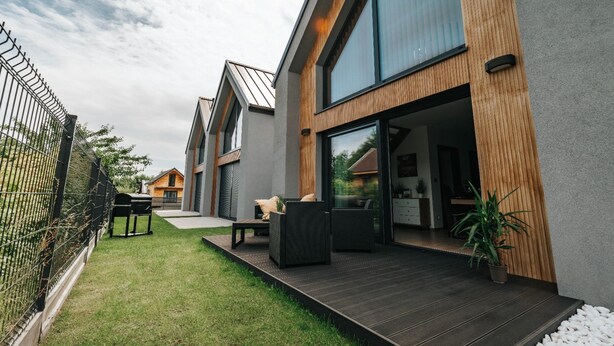 A modern residential building with a covered patio, outdoor seating, and a view of the surrounding area. - Holiday Home Near the Sea, air Conditioning (Ustronie Morskie)