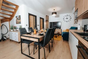 A modern living space with a dining area, kitchen, and a staircase. - Holiday Home Near the Sea, air Conditioning (Ustronie Morskie)
