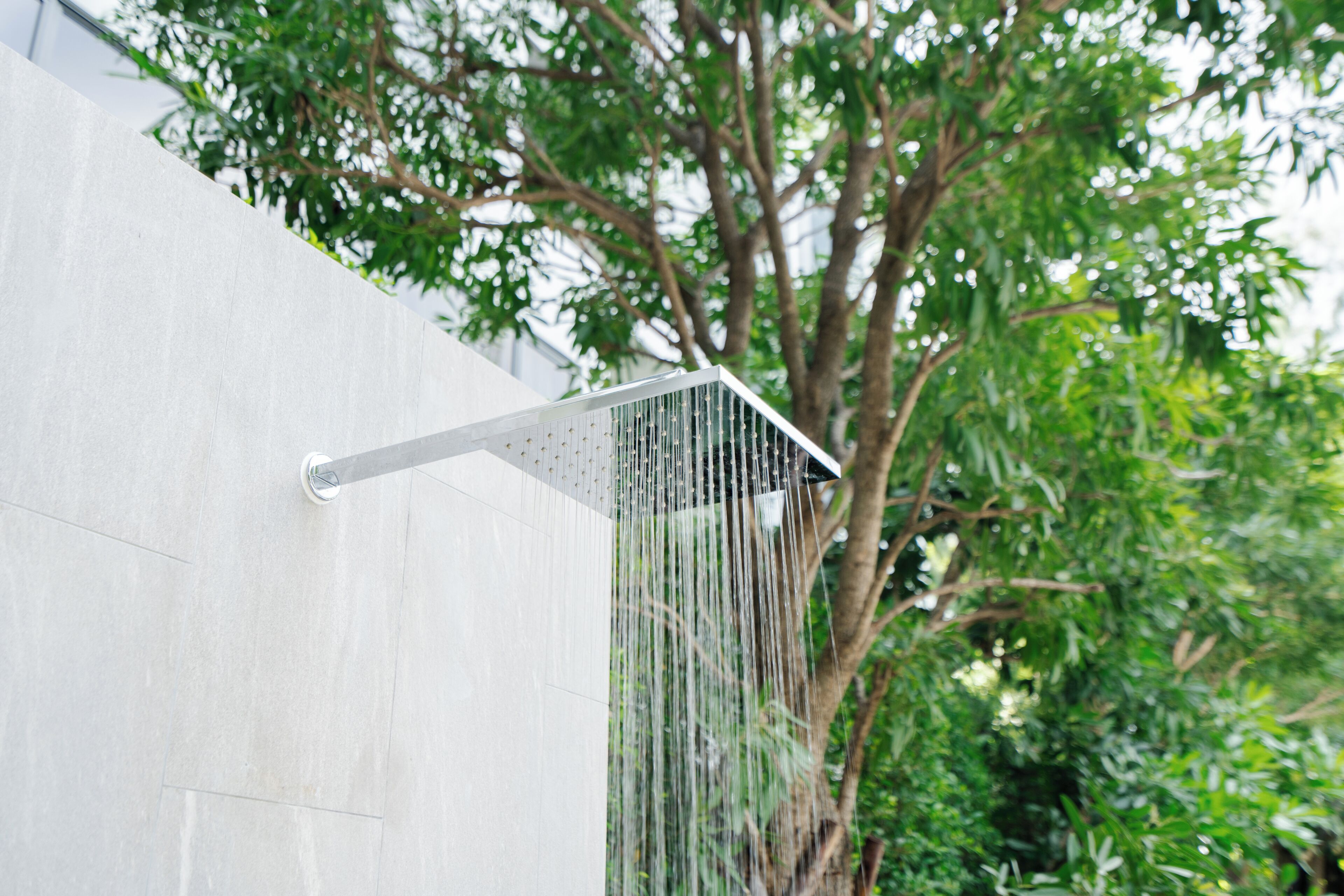 Eine moderne Duschbrause mit mehreren Wasserstrahlen, an einer weißen Wand angebracht.