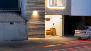 Un bâtiment moderne avec une enseigne indiquant « Sri Varee Residency » et une voiture garée devant.