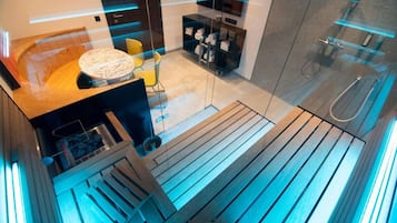 Ein modernes Badezimmer mit Duschkabine aus Glas, einer hölzernen Sitzbank und einem kleinen, runden Tisch mit Stühlen.