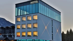 A modern hotel with a glass facade, multiple windows, and a prominent 'HOTEL' sign. -  Sleep Well 24 (Spittal an der Drau)