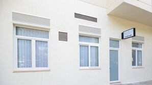 A building facade with large windows, vents, and a sign reading "RUBIO ROOMS." - Rubio Rooms by Concept Flats (València)