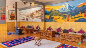 Una habitación con paredes de madera, un mural grande, un horno tradicional y un sofá con cojines.