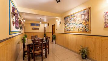 A dining area with wooden paneling, a large map mural, and a table with chairs.