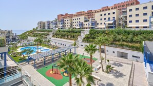 A hotel with multiple buildings, a swimming pool, and a playground area. - Apartment 'Penthouse with Terrace and Private Jacuzzi' with Sea View, Wi-Fi and Air Conditioning (Almuñécar)