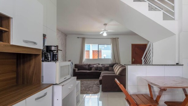 A modern apartment with a kitchen, dining area, and living room. - Casa em Itanhaém Pé na Areia com Piscina (Itanhaém)