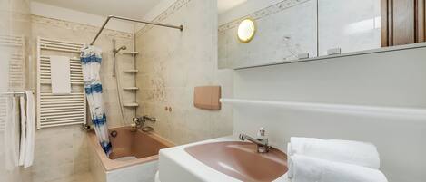 A bathroom with a bathtub, a toilet, a sink, and a shower.