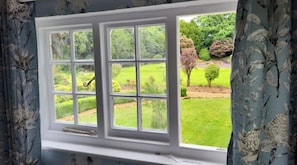 Una ventana con vistas a un jardín cuidado.