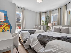 Ein Hotelzimmer mit zwei Betten, einem Schreibtisch und einem großen Fenster.