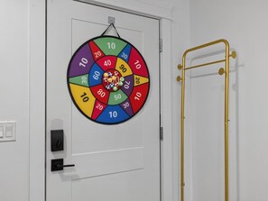 A door with a colorful wheel game, a gold ladder, and a white door frame.