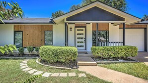 A modern two-story house with a front porch, a garage, and a well-maintained lawn. - South Austin 4BR for 9 Near Greenbelt & SoCo (Austin)