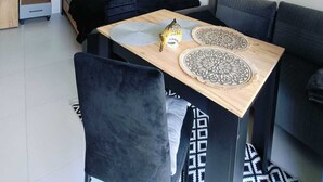 A modern, compact living space with a bed, a sofa, a dining table, and a small kitchenette. - Holiday Studio for 3 People, Mielenko (Mielno)