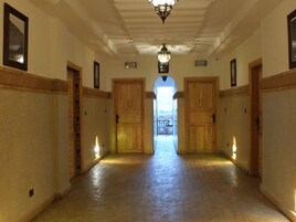 A hallway with wooden doors and a chandelier.