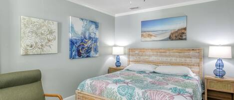 A bedroom with a bed, two nightstands, a chair, and ceiling fan.