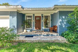 A house with a front porch, a door, and a bench.