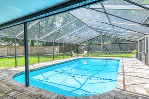 A covered outdoor swimming pool with a clear roof structure, surrounded by a brick deck. - San Rafael- Heated Pool & King Beds Near: Amphitheatre, Historic Downtown, Beach (St. Augustine)