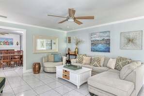 A living room with a white sofa, a coffee table, and a ceiling fan. - San Rafael- Heated Pool & King Beds Near: Amphitheatre, Historic Downtown, Beach (St. Augustine)