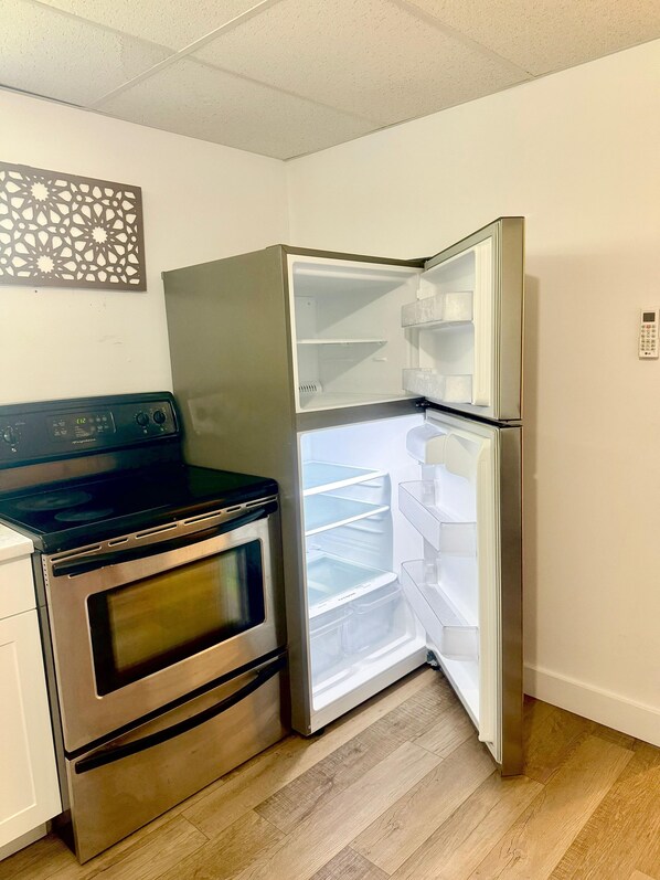 A kitchen with a stainless steel oven and a double-door refrigerator.