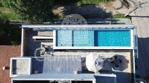 Eine Vogelperspektive eines modernen Gebäudes mit Pool auf dem Dach, einer überdachten Terrasse und einem großen Schild mit chinesischen Schriftzeichen.